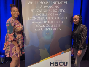 Langston University White House HBCU Scholars Lovette Mba and Charina Lancaster pose in front of a banner at the national HBCU conference